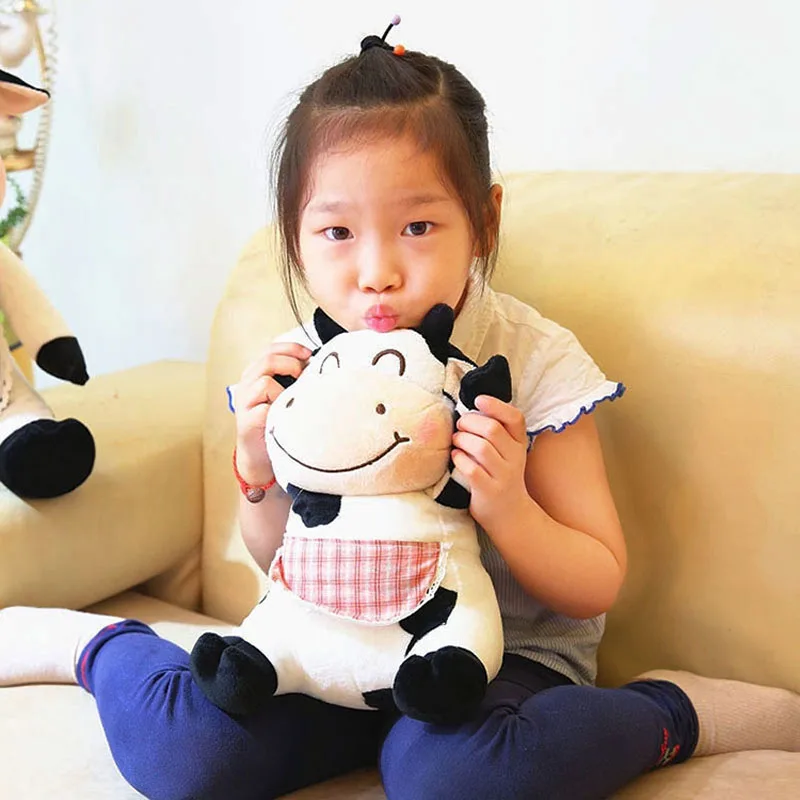 little girl holding the ear of cute cow stuffed anima toy