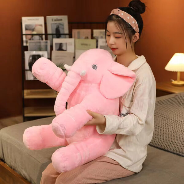 Baby Elephant Stuffed Animal A woman hugging a pink baby elephant stuffed animal.
