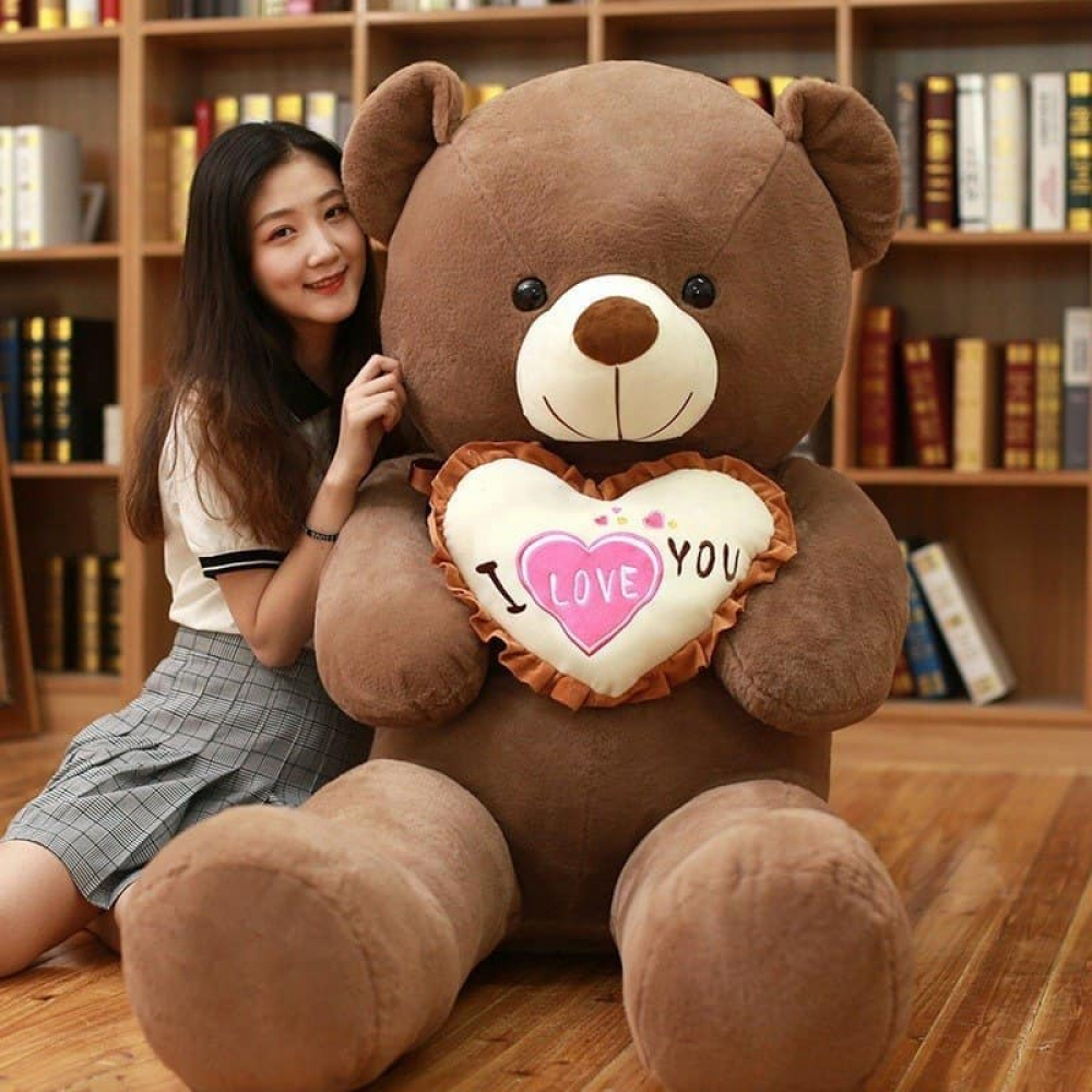Woman sitting beside a 100 cm giant brown teddy bear holding an i love you pillow