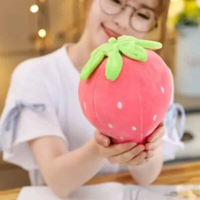 Woman holding two cute strawberry pillow and eating one strawberry plushie