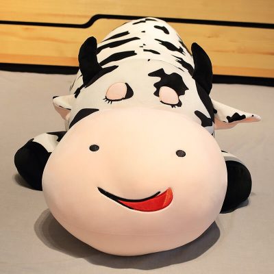 Woman sitting beside a giant cow stuffed animal