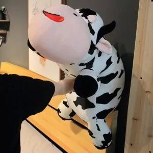 Woman Punching a Giant Cow Stuffed Animal