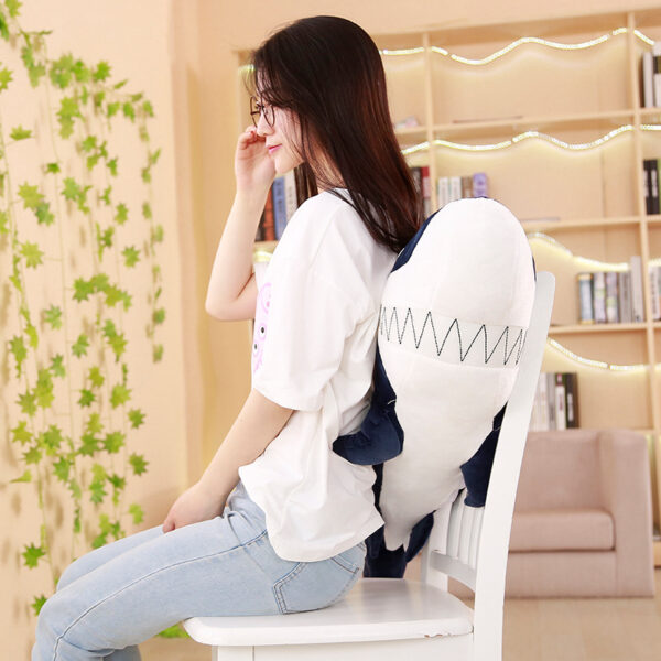 Giant Shark Plush Woman sitting behind a Giant Shark Plush